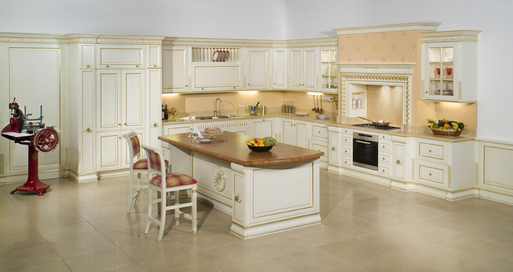 Cucina classica bianca e oro su misura con isola centrale: artigianato di lusso Baggio Arredamenti.